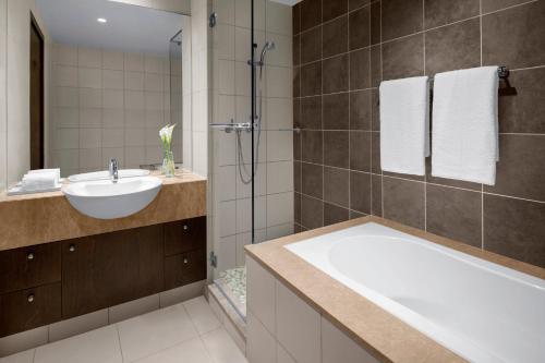 a bathroom with a tub and a sink and a shower at InterContinental Residence Suites Dubai Festival City by IHG in Dubai