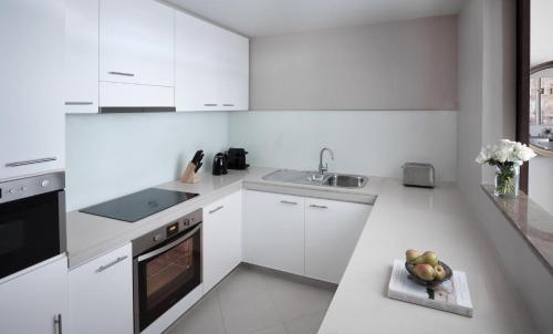 a white kitchen with a bowl of fruit on the counter at InterContinental Residence Suites Dubai Festival City by IHG in Dubai