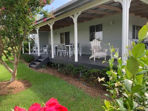 a porch of a house with chairs and a table at Cosy Cottage Linga Longa Farm in Wingham
