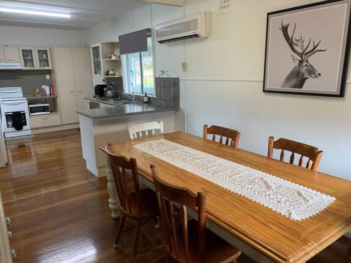 a dining room with a wooden table and chairs at Cosy Cottage Linga Longa Farm in Wingham