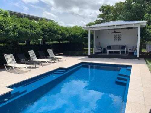 a swimming pool with chairs and a gazebo at Cosy Cottage Linga Longa Farm in Wingham
