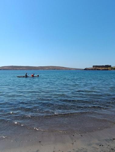 two people are in a boat in the water at Seafront & Sunsets Sigri House in Sígrion