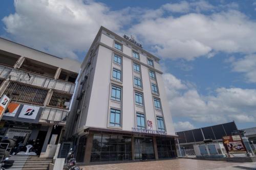 a tall white building on a city street at Collection O THE CAPITAL HOTEL in Vijayawada