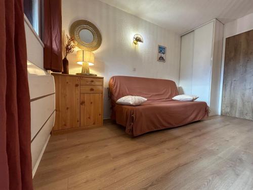 a small bedroom with a bed and a mirror at Chalets du Village - Tily Home - Studio centre village in Villard-de-Lans