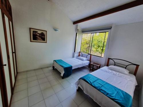 a bedroom with two beds and a window at Apartamento Melgar, Villa Flórez in Melgar