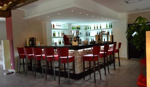 a bar with red stools in a room at Hotel Eremo in Soriano nel Cimino