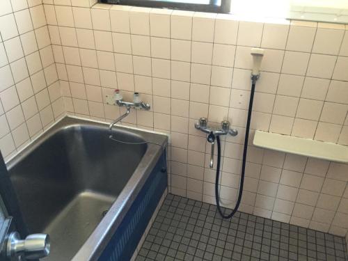 a shower in a bathroom with a tub at Minshuku Zabaru in Ishigaki Island