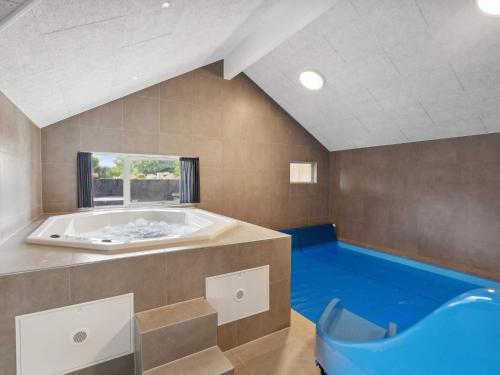 a large bathroom with a tub and a blue floor at Spacious Retreat near Beach - By Traum Ferienwohnungen in Sarup