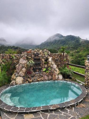 a swimming pool in front of a stone wall at Pika 03 by Pika cabins con Piscina privada in San Carlos