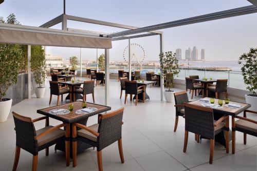 a restaurant with tables and chairs on a balcony at InterContinental Dubai Festival City by IHG in Dubai