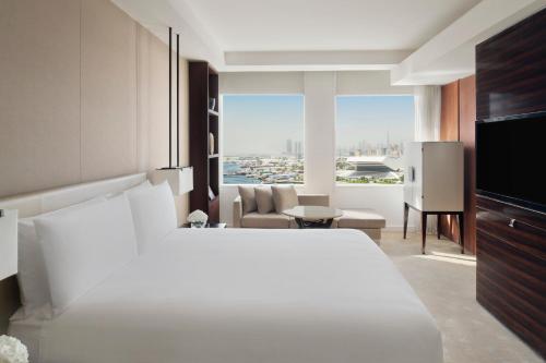 a bedroom with a white bed and a living room at InterContinental Dubai Festival City by IHG in Dubai