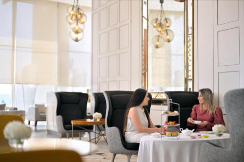two women sitting at a table with a cake at InterContinental Dubai Festival City by IHG in Dubai