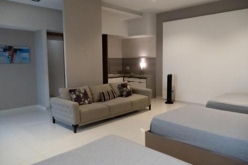 a living room with a couch and a bed at Infinity Suites Habitación Triple 105 in Cancún