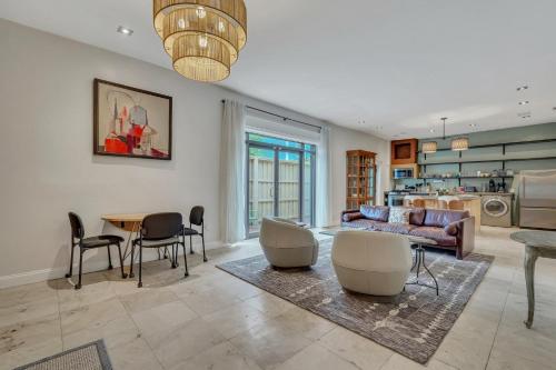 a living room with a couch and a table and chairs at The Lincoln Loft, Near Forsyth Park with Free Parking in Savannah