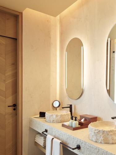 a bathroom with two sinks and two mirrors at Banyan Tree Veya, Valle de Guadalupe - A Wellbeing & Wine Resort in Valle de Guadalupe