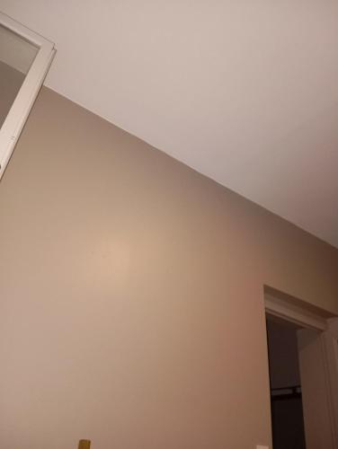 Cette chambre est dotée d'un mur blanc et d'un plafond. dans l'établissement Domaine Vierzon Mérigot, à Vierzon