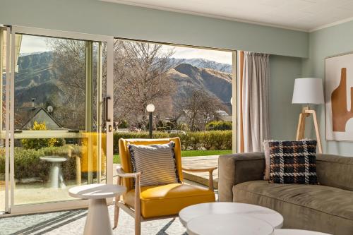 a living room with a couch and a large window at Arrowtown Motel in Arrowtown