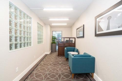 a hallway with two blue chairs and a table at Sandman Signature Lethbridge Lodge in Lethbridge