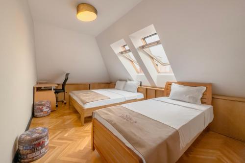 a room with two beds and a desk in it at Siera's Apartment in Pristina