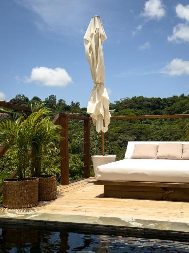 a bed sitting on a deck next to a pool at Mini Villa ATIKA Luxe Tropical pour Deux in Ducos