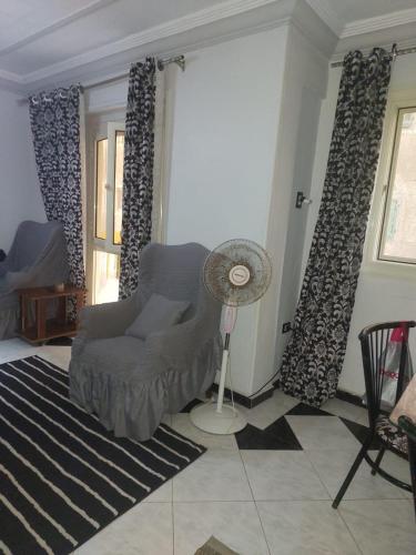 ein Wohnzimmer mit einem Stuhl und einem Ventilator in der Unterkunft شقه مفروشة علي البحر عائلات فقط in Alexandria