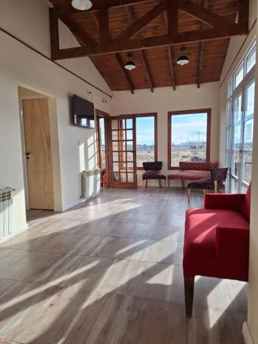 a living room with a red couch and windows at Hosteria Lago Sur in El Calafate