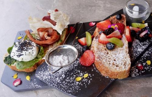 a plate of food with bread and fruit on it at Hotel Living by Armoniko in Medellín
