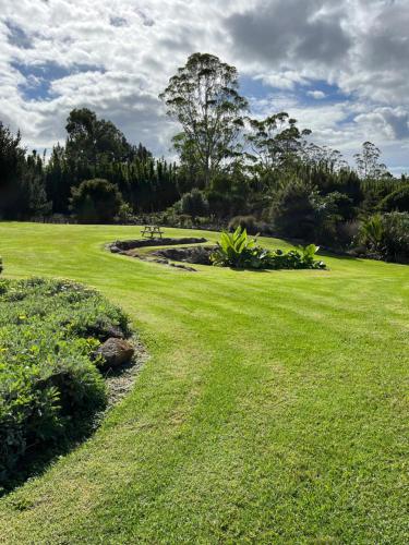 a grassy field with a park in the background at The Tropical Studio 50B in Kerikeri