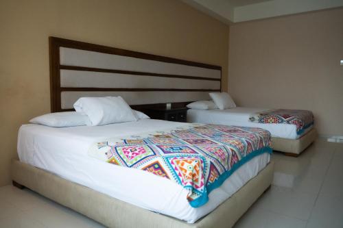 En eller flere senge i et værelse på Infinity Suites Habitación Doble 202