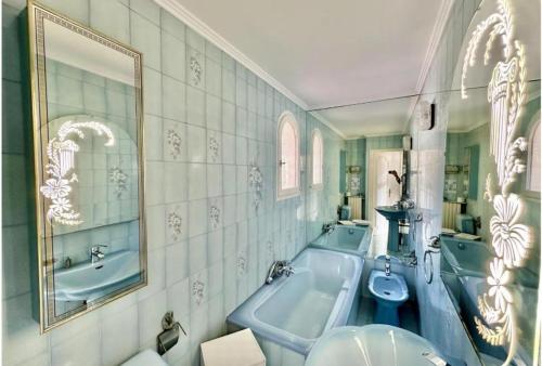 une salle de bain avec une baignoire, un lavabo et un miroir dans l'établissement Villa CAP AZUR BORD DE MER, à Roquebrune-Cap-Martin