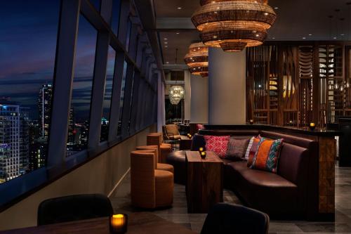 a bar with a couch and chairs and a view of a city at The Ritz-Carlton, Los Angeles L.A. Live in Los Angeles