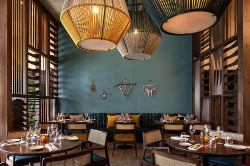 a restaurant with wooden tables and chairs and chandeliers at The Ritz-Carlton, Los Angeles L.A. Live in Los Angeles