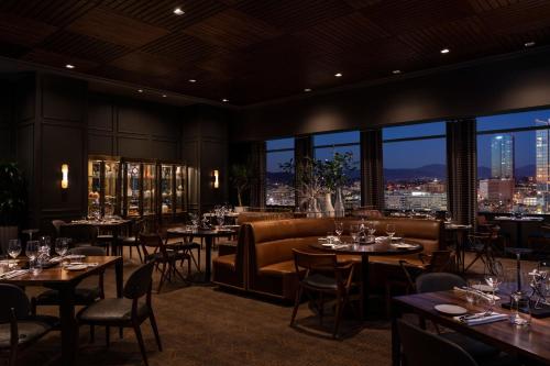 a restaurant with tables and chairs and a view of the city at The Ritz-Carlton, Los Angeles L.A. Live in Los Angeles