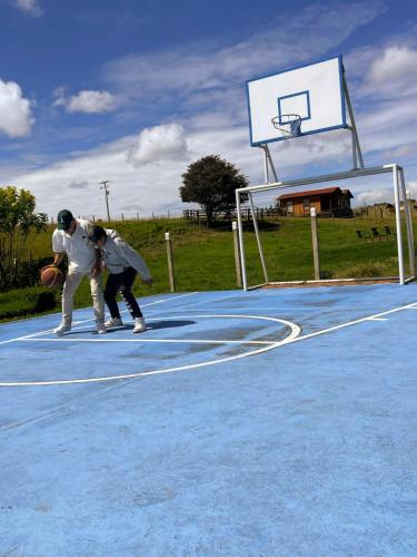 two people playing basketball on a basketball hoop at Hacienda La Yegüera in Subachoque
