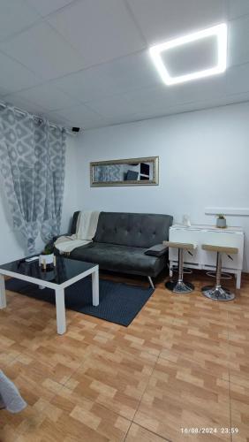 a living room with a black couch and a table at Estudio Santa Catarina in Málaga