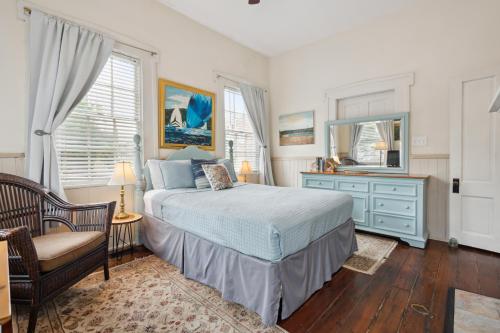a bedroom with a bed and a dresser and a mirror at Charming Savannah Duplex Courtyard Parking in Savannah
