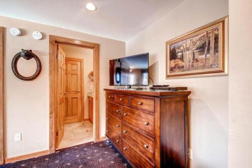 a room with a wooden dresser with a television on it at 1 Bedroom Ski In, Ski Out Mountain Vacation Rental Located Next To Historic Main Street In Downtown Breckenridge in Breckenridge