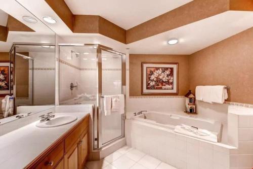 a bathroom with a tub and a sink and a shower at Ski, In Ski Out 3 Bedroom Vacation Condo With Resort Amenities That Include Exercise Center, Indoor Pool, And Hot Tubs in Beaver Creek