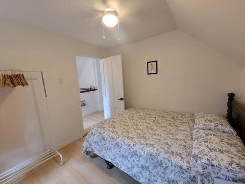 a bedroom with a bed and a light on the wall at Cozy Farmhouse 10 Minutes From The Beach! in Simcoe