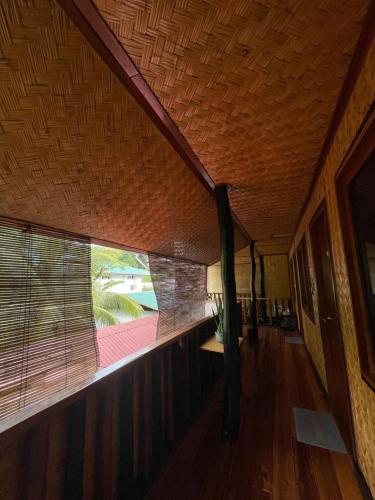 a room with a large window and a wooden floor at Hidden of Cailan Extension Transient House in El Nido