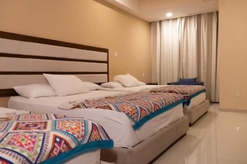 En eller flere senge i et værelse på Infinity Suites Habitación Triple 211