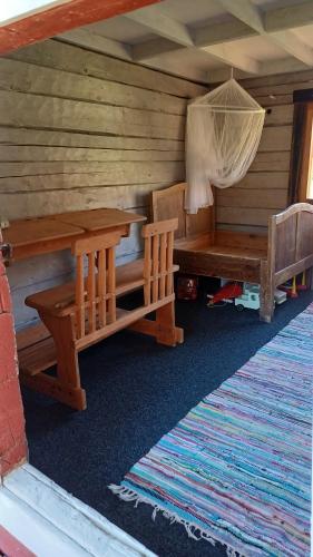 a room with a table and benches in a cabin at Loma Kallioniemi in Ähtäri