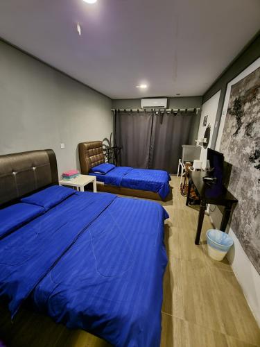 zwei Betten in einem Zimmer mit blauen Laken und einem Klavier in der Unterkunft Tamara Resort Motel in Tioman Island