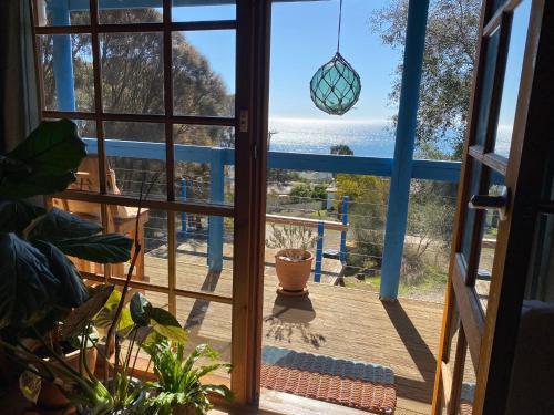 a door to a balcony with a view of the ocean at Sheoak Lodge in Penneshaw