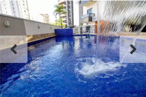 een fontein in het midden van een zwembad bij Studio Urbano Sun Square hotel in Goiânia