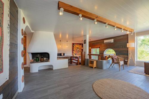 a living room with a fireplace and a dining room at Flores Garden Retreat in Santa Cruz das Flores