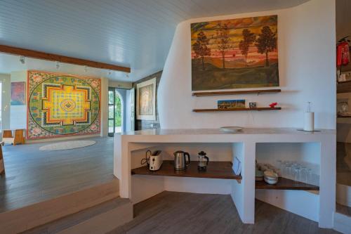 a room with a table and a painting on the wall at Flores Garden Retreat in Santa Cruz das Flores
