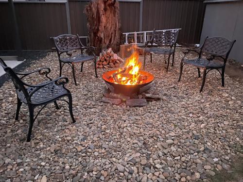 four chairs around a fire pit in a yard at Florence Lodge in Berridale
