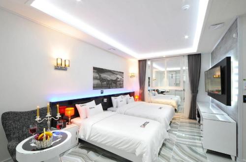 a hotel room with two beds and a flat screen tv at Mokpo Myeongpum Hotel in Mokpo