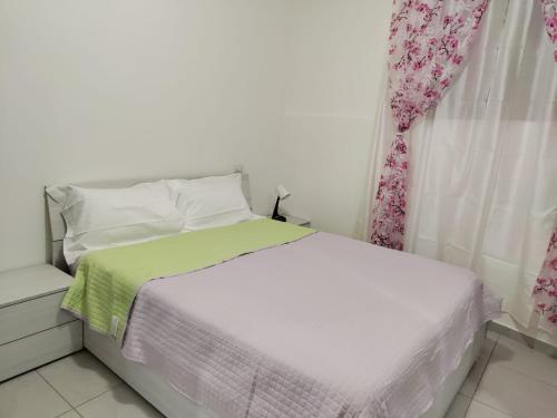 a white bed with a green blanket and a window at Lovely appartment near Como in Casnate con Bernate